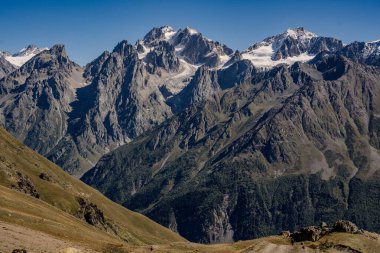 Gürcistan 'ın Kafkasya bölgesindeki Ushba Zirvesi' nde yürüyüş yolu ve kar tepeleri olan manzaralı dağ manzarası. Yüksek kalite fotoğraf