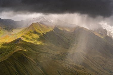 Georgia 'nın Kafkasya Dağları' ndaki Shkhara Vadisi 'nin üzerindeki Fırtına Bulutları ve Puslar Buzul ve Engebeli Yabanın Çarpıcı Manzarası. Yüksek kalite fotoğraf