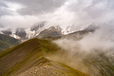 Georgia 'nın Kafkasya Dağları' ndaki Shkhara Vadisi 'nin üzerindeki Fırtına Bulutları ve Puslar Buzul ve Engebeli Yabanın Çarpıcı Manzarası. Yüksek kalite fotoğraf