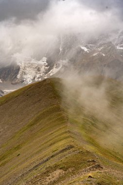 Georgia 'nın Kafkasya Dağları' ndaki Shkhara Vadisi 'nin üzerindeki Fırtına Bulutları ve Puslar Buzul ve Engebeli Yabanın Çarpıcı Manzarası. Yüksek kalite fotoğraf