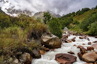 Ushguli Gürcistan yakınlarındaki Kafkasya Dağları 'ndaki Shkhara Buzulu: Engebeli tepeleri, kayaları ve sisli gökyüzü olan görkemli Alp manzarası. Yüksek kalite fotoğraf