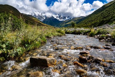 Ushguli Gürcistan yakınlarındaki Kafkasya Dağları 'ndaki Shkhara Buzulu: Engebeli tepeleri, kayaları ve sisli gökyüzü olan görkemli Alp manzarası. Yüksek kalite fotoğraf