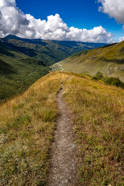 Svaneti Georgia yakınlarındaki Ushguli Dağı 'nda yürüyüş yapmak: Kafkasya boyunca yeşil vadiler ve bulutlarla giden manzara yolu. Yüksek kalite fotoğraf