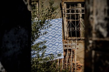 Dışında paslı pencere ızgarası ve mavi desenli kumaş olan eski ev Tiflis Georgia 'da yıpranmış duvarları ve solmuş mimarisi olan eski şehir manzarası. Yüksek kalite fotoğraf