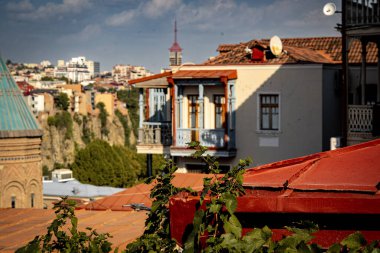 Tiflis Georgia 'daki eski ahşap balkon: Yıkanmış boya, kırsal pencereler ve akşam vakti çamaşır asma ile yıpranmış mimari. Yüksek kalite fotoğraf