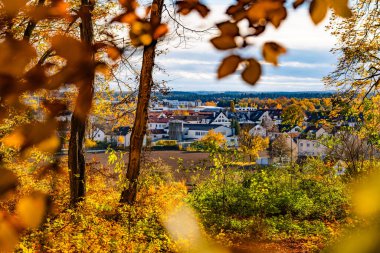 Gilching, Bavyera 'daki büyüleyici kır evi ahşap çitli rahat bir ev, sonbahar ağaçları ve huzurlu köy ortamında sıcak altın bir ışık. Yüksek kalite fotoğraf