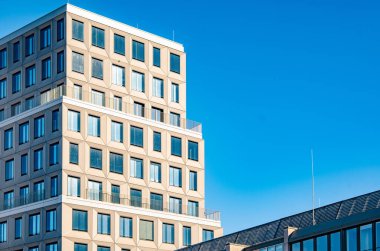 Münih 'teki Modern Ofis Kulesi: Temiz Mavi Gökyüzü Altında Geometrik Yüzlü Çağdaş Şehir Mimarisi ve Cam Pencereler. Yüksek kalite fotoğraf