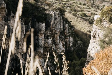 Sicilya 'daki Syracuse yakınlarındaki Gole Della Stretta Kanyonu dramatik kireçtaşı uçurumları, derin kaya oluşumları ve engebeli tabiattaki Akdeniz bitkileri. Yüksek kalite fotoğraf