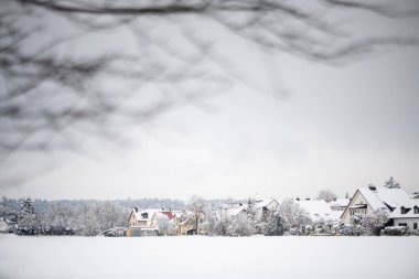 Almanya 'nın Bavyera kentinde, ön planda açık bir tarla bulunan taze karla kaplı Emmering köyündeki evler. Yüksek kalite fotoğraf