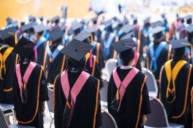 Üniversite mezunlarının dikiz aynaları üniversite mezuniyet töreninde derece ödülü için sırada. Üniversite mezunları üniversite mezuniyet töreninde toplanıyorlar. Mezunların kalabalığı.