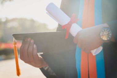 Bir üniversite mezununun seçici ve yakın çekim odağı mezuniyet töreninde diploma ve mezuniyet şapkası bulundurur..