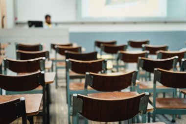 Sınıfta düzenlenmiş ahşap konferans sandalyeleri. Boş üniversite sınıfı, bir sürü ahşap konferans koltuğu var ama öğrenci yok. Okul konseptine dönelim..