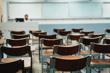 Sınıfta düzenlenmiş ahşap konferans sandalyeleri. Boş üniversite sınıfı, bir sürü ahşap konferans koltuğu var ama öğrenci yok. Okul konseptine dönelim..