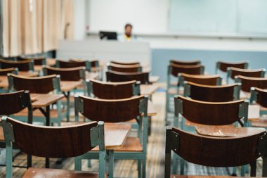 Sınıfta düzenlenmiş ahşap konferans sandalyeleri. Boş üniversite sınıfı, bir sürü ahşap konferans koltuğu var ama öğrenci yok. Okul konseptine dönelim..