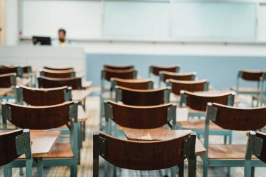 Sınıfta düzenlenmiş ahşap konferans sandalyeleri. Boş üniversite sınıfı, bir sürü ahşap konferans koltuğu var ama öğrenci yok. Okul konseptine dönelim..