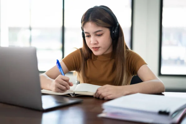 Sonrisa Joven Estudiante Asiática Lleva Auriculares Inalámbricos Escribir Cuaderno Para —  Fotos de Stock