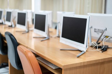 Bilgisayar odasında iyi düzenlenmiş masaüstü monitörlerinin bulanık ve seçici odağı. Lisedeki sınıfta bilgisayarlar. İlkokuldaki boş bilgisayar odası.