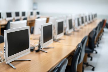 Bilgisayar odasında iyi düzenlenmiş masaüstü monitörlerinin bulanık ve seçici odağı. Lisedeki sınıfta bilgisayarlar. İlkokuldaki boş bilgisayar odası.
