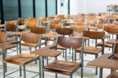 Wooden chairs are well arranged in the classroom. Empty classroom with vintage tone wooden chairs. Back to school concept.	