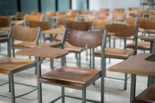 Wooden chairs are well arranged in the classroom. Empty classroom with vintage tone wooden chairs. Back to school concept.