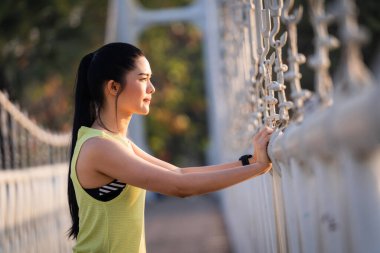 Spor kıyafetli genç bir Asyalı atlet sabah spor öncesi antrenman, koşu ve spor antrenmanlarından önce ısınma hareketleri yapıyor. Spor ve eğlence.