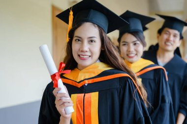 Mezuniyet elbisesi ve havan topu şapkasıyla mezun olan Asya Üniversitesi mezuniyet töreninde elde elde eğitim başarısını kutluyor. Mezuniyetleri kutlarım.