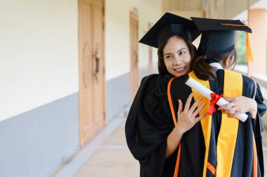 Mezuniyet elbisesi ve havan topu şapkasıyla mezun olan Asya Üniversitesi mezuniyet töreninde elde elde eğitim başarısını kutluyor. Mezuniyetleri kutlarım.