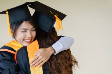 Mezuniyet elbisesi ve havan topu şapkasıyla mezun olan Asya Üniversitesi mezuniyet töreninde elde elde eğitim başarısını kutluyor. Mezuniyetleri kutlarım.