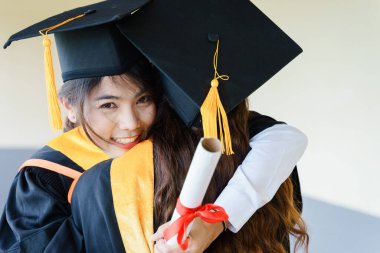 Mezuniyet elbisesi ve havan topu şapkasıyla mezun olan Asya Üniversitesi mezuniyet töreninde elde elde eğitim başarısını kutluyor. Mezuniyetleri kutlarım.