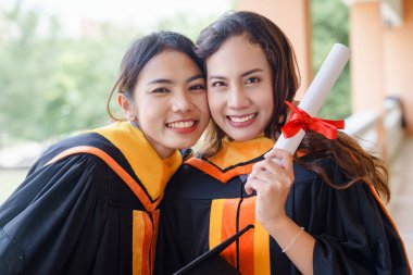 Mezuniyet elbisesi ve havan topu şapkasıyla mezun olan Asya Üniversitesi mezuniyet töreninde elde elde eğitim başarısını kutluyor. Mezuniyetleri kutlarım.