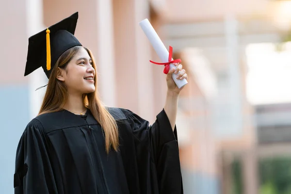 Young Happy Asian Woman University Graduate Graduation Gown Mortarboard Holds — Stock Photo, Image