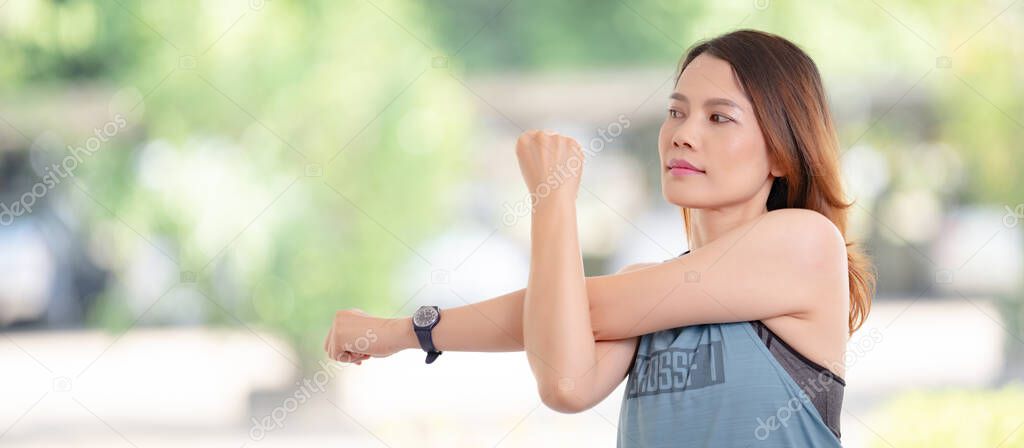 Beautiful Asian woman in sports outfits doing stretching before workouts at hot during COVID-19 pandemic to keep a healthy life. Healthy young woman stretching and warming up to workouts