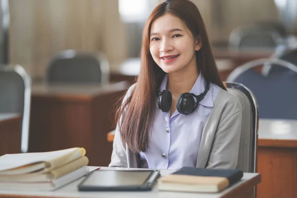 若い十代の女性のストックフォト大学の教室でノートに学生の制服研究や書き込みでアジアの大学生 — ストック写真