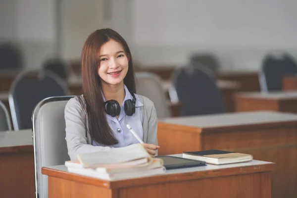 若い十代の女性のストックフォト大学の教室でノートに学生の制服研究や書き込みでアジアの大学生 — ストック写真