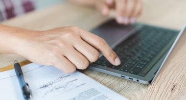 Cropped close-up image of a businessman`s hands typing working on a laptop at the home office. Freelancer, remote occupation, tutor, student e-learning concept