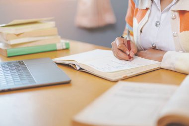İnternette okuyan, kitap okuyan, üniversite kütüphanesinde dijital tablet ya da dizüstü bilgisayar kullanan stresli bir Asyalı üniversite öğrencisi.