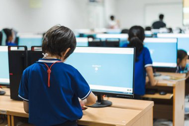 Eğitim oyunları oynayan ve bilgisayar sınıfında okuyan bir grup öğrencinin dikiz görüntüsü