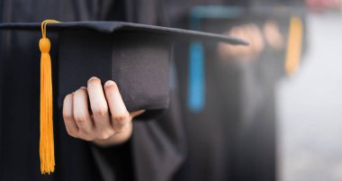 Mezuniyet elbisesi içinde mezuniyet şapkası takan üniversite mezunlarının kapalı ve seçici fotoğrafları.