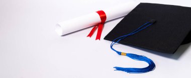 Mezuniyet havan ve diploma sertifikasının resmi beyaz zemin üzerinde izole edilmiş ve metin eklemek için negatif fotokopi alanı var. Mezuniyet şapkası. Masada beyaz arka plan var.