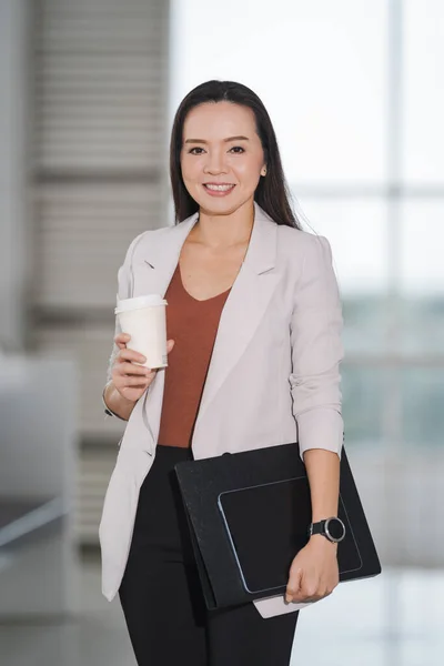 ビジネスビルでテイクアウトコーヒーカップ ドキュメントファイル デジタルタブレットを保持している幸せなアジアのビジネスマンの女性 — ストック写真