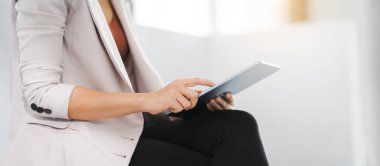 Kahve molası sırasında ofis koridorunda dijital tablet kullanan Asyalı iş kadını mesleği