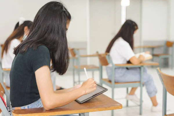 アジアの大学生は 学校に戻って保護面を着用し 教室で勉強社会的距離を保ちます — ストック写真