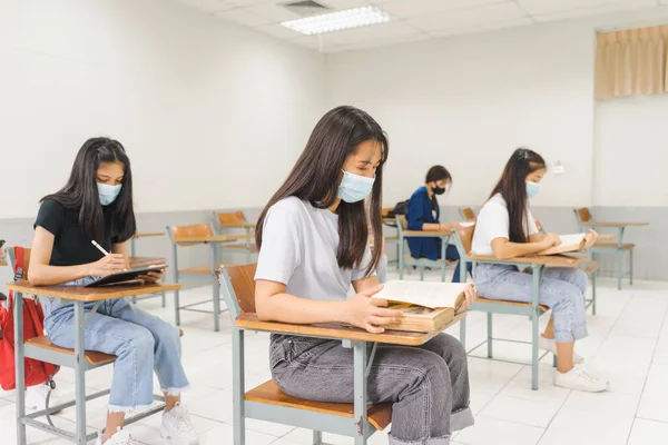 Asiatiska Högskolestudenter Tillbaka Till Skolan Bära Skyddande Facemask Och Hålla Stockbild
