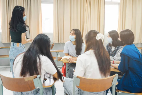 학생들은 얼굴을 보호하기 마스크를 착용하고 교실에서 수업을 — 스톡 사진