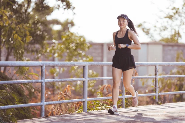 在阳光明媚的夏日里 快乐地微笑着的亚洲成年女子在公园里慢跑 成熟的女性慢跑 过着积极 健康的生活 — 图库照片