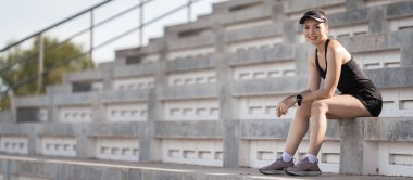 Vücudunu güçlendirmek için stadyumun beton merdivenlerinde koşan sağlıklı, yetişkin bir Asyalı kadın.