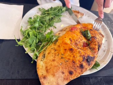 Lezzetli İtalyan calzone taze roka salatası.