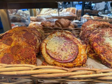 Fırın sepetinde sergilenen çeşitli mini pizzalar.