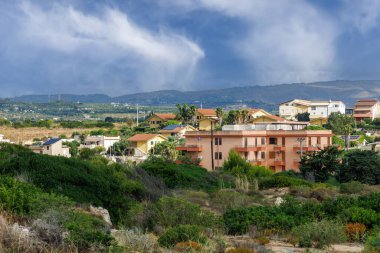 Sicilya oteli yemyeşil çalılar ve dağlarla çevrili. Sicilya, İtalya - 10 Ekim 2025