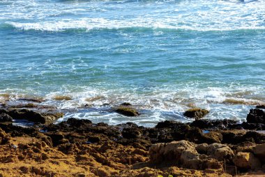 Kayalıkların yakınındaki deniz dalgası dokusu ve turkuaz su.